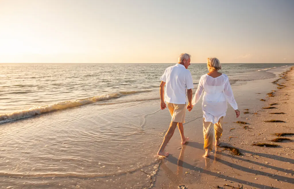 Older couple walking on the beach